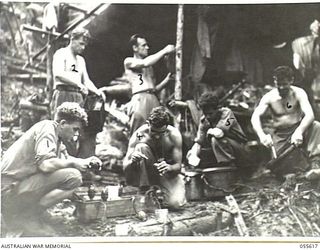 GOODVIEW, NEW GUINEA, 1943-08-11. TROOPS OF "C" COMPANY, 2/7TH BATTALION PREPARING HAND GRENADES. LEFT TO RIGHT:- VX59231 PRIVATE D. WHITLOW; VX23562 PRIVATE J. A. POWELL; N33405 PRIVATE R. L. ..