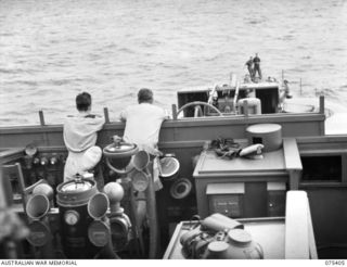 AT SEA. 1944-08-20. OFFICERS OF THE RAN ON THE BRIDGE OF THE FRIGATE, HMAS "BARCOO" WHILE CARRYING TROOPS OF THE 25TH INFANTRY BATTALION FROM SIAR TO POTSDAM