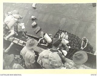 BOUGAINVILLE ISLAND, SOLOMONS. 1944-11-01. TROOPS OF THE 3RD AUSTRALIAN DIVISION AND ATTACHED TROOPS CLIMBING DOWN THE NETS OVER THE SIDE OF THE LIBERTY SHIP, LINDLEY M. GARRISON INTO AMERICAN ..