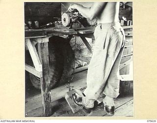 ORO BAY, NEW GUINEA. 1943-07. A HAND AND FOOT OPERATED EMERY STONE AT THE UNIT TRANSPORT WORKSHOP