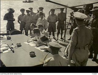 Nauru Island, South Pacific. 1945-09-30. Captain Hisayuki Soeda and Lieutenant Commander Kishimoto, the senior Japanese Army and Naval officers on Nauru Island, signing the Instrument of Surrender ..