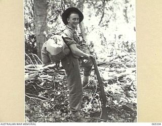 KILIGIA, NEW GUINEA. 1944-03-20. MR. PAUL BECKER OF THE AUSTRALIAN PUBLIC RELATIONS FIELD UNIT STANDING IN THE JUNGLE