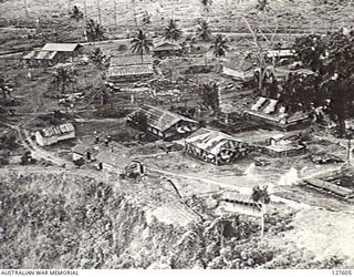 RABAUL, NEW BRITAIN. 1943-11-02. BUILDINGS (SOME CAMOUFLAGED) ON THE OUTSKIRTS OF THE TOWN BEFORE THE STRIKE AND AFTER THE RAID