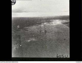 New Guinea. Aerial view of the terrain showing a marked airfield landing strip