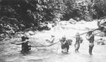 Native constables carrying patrol officer? across river, New Guinea, c1924 to ?