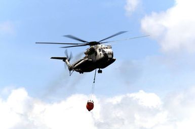 A US Marine Corps (USMC) CH-53D Sea Stallion, Marine Heavy Helicopter Squadron-463 (HMH-463), Marine Corps Air Station (MCAS) Kaneohe Bay, performs a fire bucket drill on the island of Oahu, Hawaii (HI)