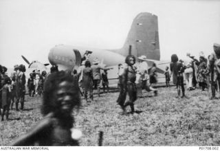Local highland natives crowding around a Douglas Dakota C47 aircraft of the united states air force, on the airstrip at Bena Bena in the Mount Hagen area. Several American missionaries are ..