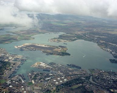 Aerial view of Pearl Harbor with the nuclear-powered aircraft carrier USS ENTERPRISE (CVN 65) visible, center