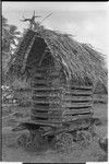 Yam house in Tukwaukwa, designs painted on roof supports, sculpture at peak of roof