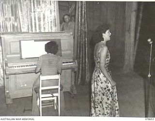 LAE AREA, NEW GUINEA. 1945-01-28. PAULINE GARRICK, SOPRANO (1), ACCOMPANIED BY MISS MAMIE REID, AUSTRALIAN BROADCASTING COMMISSION (PIANIST), (2) AND MEMBER OF THE DICK BENTLEY CONCERT PARTY ..