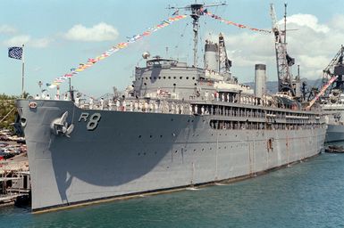 Crew members man the rails of the repair ship USS JASON (AR 8) during the designation and departure ceremony for the Unknown Serviceman of the Vietnam Era. The ship is displaying the union jack and a rainbow of signal flags