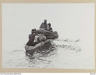 TINIAN, BOUGAINVILLE, 1945-07-18. A CANOE LOADED WITH BLANKETS MOVES AWAY FROM ML1327, A MOTOR LAUNCH USED BY THE ALLIED INTELLIGENCE BUREAU TO PICK UP TEN NETHERLANDS EAST INDIES ARMY PERSONNEL ..
