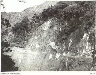 NEW GUINEA. 1944-07-09. THE STEELE FALLS SECTION OF THE NEW WAU-BULLDOG ROAD UNDER CONSTRUCTION WHERE IT RUNS ALONG A CLIFF FACE OF STEEPLY INCLINED ROCK STRATA