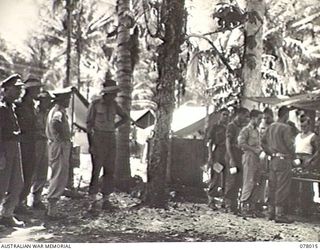 MALMAL VILLAGE, NEW BRITAIN. 1944-12-25. VX27 MAJOR GENERAL A. H. RAMSAY, CBE, DSO, ED, GENERAL OFFICER COMMANDING 5TH DIVISION AND HIS SENIOR OFFICERS AT THE MEN'S MESS DURING THE SERVING OF ..