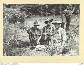 BOUGAINVILLE. 1945-03-30. LORD WAKEHURST, GOVERNOR OF NEW SOUTH WALES (3), AT PLATOON HEADQUARTERS INSPECTING A 2-INCH MORTAR DURING AN EXERCISE IN THE DEPLOYMENT OF A PLATOON, 15 INFANTRY ..