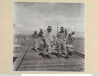 WIDE BAY, NEW BRITAIN, 1945-05-02. MAJOR-GENERAL H.C.H. ROBERTSON, GENERAL OFFICER COMMANDING 5 DIVISION (1), ACCOMPANIED BY OFFICERS DURING HIS TOUR OF THE AREA. IDENTIFIED PERSONNEL ARE:- CAPTAIN ..