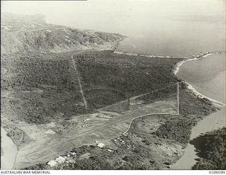 Possibly Salamaua, New Guinea. C. 1943. Aerial view of the airfield on the coast with the alighting area in the centre background facing north north-west. (Compare OG0605C, OG0606H)