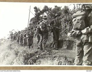 SHAGGY RIDGE, NEW GUINEA. 1943-12-27. PERSONNEL OF D COMPANY, 2/16TH AUSTRALIAN INFANTRY BATTALION, 21ST AUSTRALIAN INFANTRY BRIGADE, MOVING ALONG A TRACK ON THEIR WAY TO THE FRONT LINE DURING THE ..