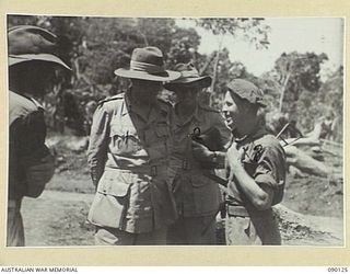 COMPTON RIVER AREA, BOUGAINVILLE. 1945-03-31. LORD WAKEHURST, GOVERNOR OF NEW SOUTH WALES (1), AND LIEUTENANT-COLONEL DWYER (2), TALKING TO PRIVATE A. BAMBACK, 26 INFANTRY BATTALION (3), DURING THE ..