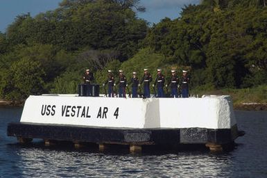 US Marine Corps (USMC) Marines, Marine Aircraft Group 24 (MAG-24), Marine Corps Base (MCB) Hawaii, Hawaii (HI), stand at parade rest prior to a twenty-one gun salute on the USS VESTAL (AR 4) mooring quay. The VESTAL, a repair ship, was moored outboard of the battleship USS ARIZONA (BB 39) at quay F-7 during the attack on Pearl Harbor. Hit by two bombs and further damaged when ARIZONA's forward magazines exploded, she was repaired and transferred to the South Pacific in August 1942. There she mended many combat damaged ships during difficult times of the Guadalcanal and Central Solomons campaigns