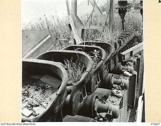 WAU - LAE ROAD, NEW GUINEA, 1944-02-20. AN ABANDONED GOLD MINING DREDGE ON THE BULOLO RIVER APPROXIMATELY A MILE SOUTH OF THE BULOLO - WATUT RIVER JUNCTION. ALTHOUGH GRASS GROWS IN THE DREDGE'S ..