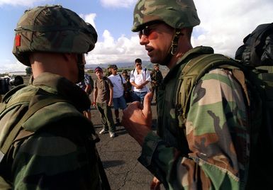 CWO3 Dough McKenzie (right), attached to the 13th Marine Expeditionary Unit, Camp Pendleton, California, Command Element makes last minute preparation before the Non-combatant Evacuation Operation (NEO) during exercise RIMPAC 98