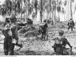 1943-01-08. PAPUA, GIROPA POINT. AUSTRALIAN- MANNED GENERAL STUART M3 TANKS ATTACK JAPANESE PILLBOXES IN THE FINAL ASSAULT ON BUNA. MEN OF B COMPANY, 2/12TH BATTALION, STAND BY AS A TANK BLASTS ..