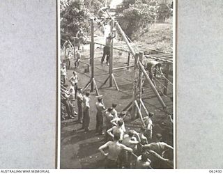 THORPVILLE, NEW GUINEA. 1943-12-07. PATIENTS EXERCISING IN THE OPEN AIR GYMNASIUM OF THE PHYSIOTHERAPY SECTION, 113TH AUSTRALIAN CONVALESCENT DEPOT, ON THE BANK OF THE EWOROGO CREEK