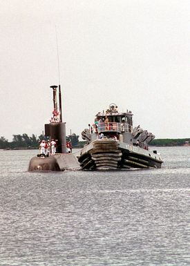 A U.S. Navy tug boat lends a line to the KOREA SOUHT REPUBLIC CHANG BOGO (Type 209) CLASS (1200) submarine CHOI MUSON (SSK 063) as it enters into Apra Harbor, Guam. The CHOI MUSON along with her crew of 33, is the first South Korean submarine to visit the Island of Guam