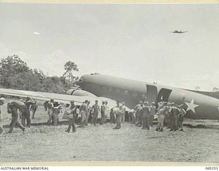 UNITED STATES TROOPS OF THE 32ND UNITED STATES DIVISION UNLOADING THE SWAMP RAT", A DOUGLAS C47 AIRCRAFT, AFTER IT HAD BECOME BOGGED AT THE END OF THE NEW AIRSTRIP. THIS AIRCRAFT WAS THE FIRST ..