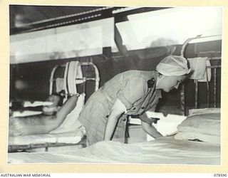 BOUGAINVILLE ISLAND. 1945-01-23. NFX138810 SISTERS E.A. LALOR MAKING UP A BED IN THE TENT WARD OF THE 2/1ST AUSTRALIAN GENERAL HOSPITAL