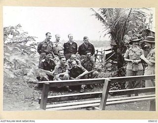 WUNUNG, NEW BRITAIN. 1945-09-04. SISTER G.M. DWYER, AUSTRALIAN ARMY NURSING SERVICE (2), WATCHED BY SISTER M.H. JONES, AUSTRALIAN ARMY NURSING SERVICE (1), TAKING A PHOTOGRAPH OF A GROUP OF ..