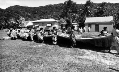 Women spreading or taking up a carpet of masi and mats.