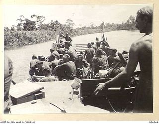 JABA RIVER AREA, BOUGAINVILLE, SOLOMON ISLANDS. 1944-12-18. 15 INFANTRY BATTALION SUPPORT TROOPS, GUIDED BY THE HELMSMAN AT THE FOREGROUND, SUCCESSFULLY NEGOTIATING THE RIVER BY BARGE TO ASSIST D ..