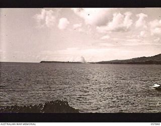 FINSCHHAFEN, NEW GUINEA. 1943-09-23. EXPLOSION OF BOMBS DROPPED BY BOSTON BOMBER AIRCRAFT OF THE RAAF, ON THE AERODROME AND JETTY FOLLOWING A HEAVY DIVE BOMBING ATTACK BY VULTEE VENGEANCE DIVE ..