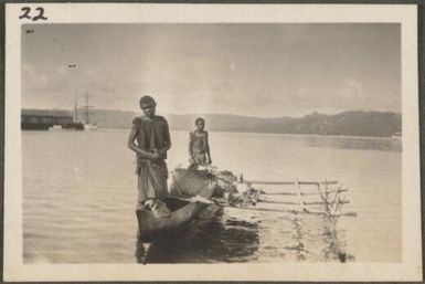 Two Papuan men standing in a canoe, Blanche Bay, New Britain Island, Papua New Guinea, approximately 1916