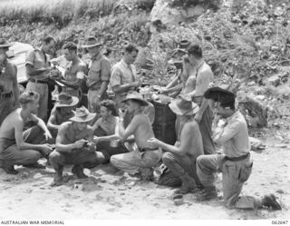 WANDOKAI BEACH, NEW GUINEA. 1943-12-31. TROOPS OF THE 2/6TH AUSTRALIAN FIELD REGIMENT, 7TH AUSTRALIAN DIVISION ENJOYING THEIR LUNCH ON THE BEACH. IDENTIFIED PERSONNEL ARE: NX16398 SERGEANT SKY (1); ..