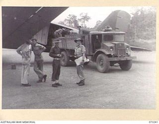 LAE, NEW GUINEA. 1944-05-19. NO. 2 AIRCRAFT, A DOUGLAS C47 TRANSPORT AIRCRAFT OF THE UNITED STATES ARMY AIR FORCE, BEING UNLOADED AT THE AIRFIELD. THE AIRCRAFT HAS COMPLETED A JOURNEY CARRYING ..