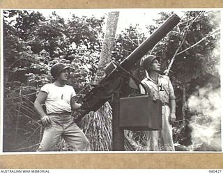 GODOWA, NEW GUINEA. 1943-11-05. CORPORAL K. TENNEY OF PORTLAND MAINE, USA, (LEFT) AND PRIVATE R. WARNOCK OF OHIO, USA, (RIGHT), BOTH OF THE UNITED STATES 102ND COAST ARTILLERY BATTALION, MANNING A ..