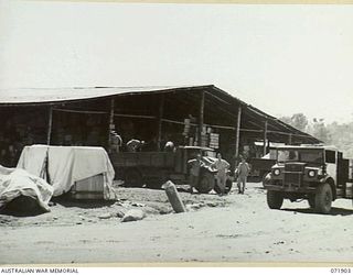 LAE, NEW GUINEA. 1944-03-30. PERSONNEL OF THE 103RD FIELD AMMUNITION DEPOT AT THE TRAFFIC SHED. THE SORTING OF ALL INWARD AND OUTWARD STORES OCCURS AT THIS POINT