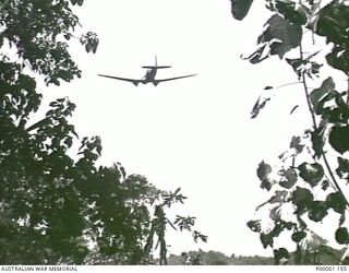 THE SOLOMON ISLANDS, 1945-05. A SUPPLY DROPPING RAAF C47 AIRCRAFT PASSING OVER AN AUSTRALIAN ARMY CAMP AT NORTH BOUGAINVILLE