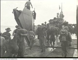 LOS NEGROS ISLAND, ADMIRALTY ISLANDS. 1944-03-18. RAAF AIRMEN AND AMERICAN TROOPS GOING ASHORE FROM A LANDING CRAFT TO REINFORCE THE EARLIER LANDINGS AT MOMOTE