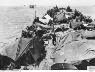 1943-09-28. COMBINED SEA, LAND AND AIR OPERATIONS AGAINST JAPS. CANVAS SHELTERS RIGGED BY AUSTRALIANS ON A BEACH LANDING CRAFT, PART OF THE GREAT ALLIED CONVOY ON ITS WAY TO LAE. THE CONVOY ..