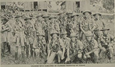 Soldiers with garlands of flowers presented by Fijians