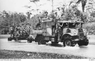 1943-09-25. NEW GUINEA. ADVANCE ON LAE. A NUMBER 6 ARTILLERY TRACTOR TOWING A 40 MM BOFORS GUN ACROSS THE BUREP RIVER ON THE WAY TO LAE