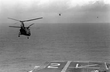 Three CH-46E Sea Knight helicopters of Marine Medium Helicopter Squadron 261 (HMM-261) depart the amphibious assault ship USS SAIPAN (LHA 2) during a rehearsal for Operation Sharp Edge. The SAIPAN is on station off the coast of Liberia