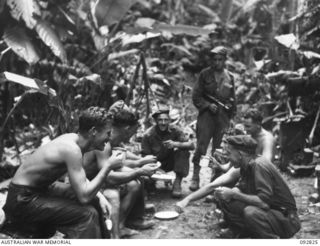 SORAKEN AREA, BOUGAINVILLE, 1945-06-07. MEMBERS OF B COMPANY, 31/51 INFANTRY BATTALION TACTICAL HQ, HAVING A HASTY MEAL BEFORE GOING OUT ON PATROL. IDENTIFIED PERSONNEL ARE:- PTE J.F. DEPPLER (1); ..