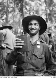 1943-08-30. NEW GUINEA. 2/5TH BATTALION STRETCHER BEARER CORPORAL LESLIE C. "BULL" ALLEN MM, AGE 26, OF BALLARAT, VIC, ABOUT TO DRINK FROM A WATER BOTTLE. ALLEN CARRIED OUT UNDER FIRE TWELVE ..