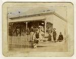 View of flooded street, showing group of people standing in verandah and in a boat in front of the Collingwood family home, Albion, Brisbane, Feb 1893