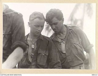 SUAIN PLANTATION, NEW GUINEA. 1944-12-06. PRIVATE F.L. BOYLE, (1), AND PRIVATE N.K. HARTH, (2), MEMBERS OF A COMPANY, 2/4 INFANTRY BATTALION, FILLING THEIR WATER BOTTLES WITH STERILISED WATER ON ..